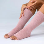 Pink bamboo compression foot sleeve being pulled onto foot