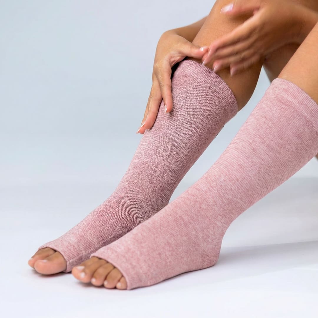 Pink bamboo compression foot sleeve being pulled onto foot