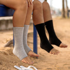 Gray and black bamboo compression foot sleeves worn while standing
