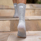 Gray bamboo compression foot sleeve worn while walking upstairs