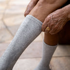 Gray bamboo compression foot sleeve worn while seated