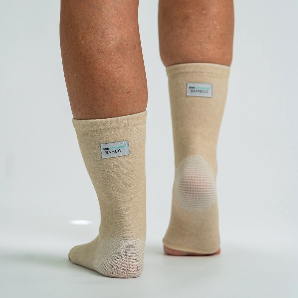 Cream bamboo compression foot sleeves worn on both feet