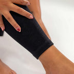 Close-up of black compression leg sleeve around the thigh