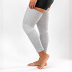Gray full-leg compression sleeve worn while bending the knee